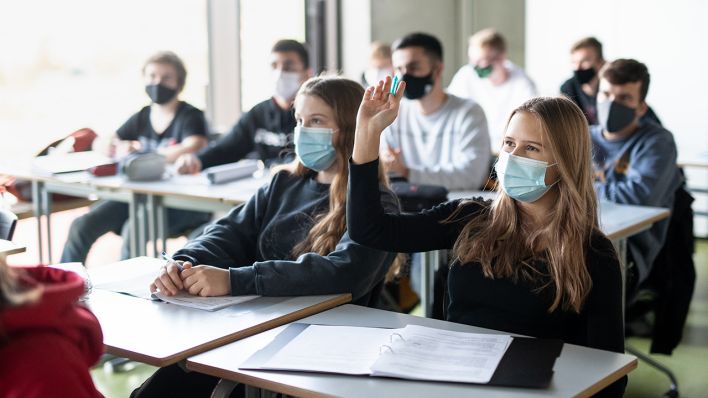 Schülerinnen und Schüler nehmen mit Mund- und Nasenschutz am Unterricht teil. (Quelle: dpa/Matthias Balk)