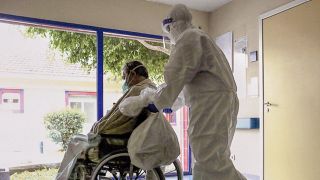 Symbolbild: Ein Covid-19-Patient wird im Curry-Cabral-Krankenhaus im Rollstuhl geschoben. (Quelle: dpa/Franca)