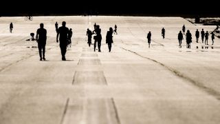Auf dem Tempelhofer Feld sind Silhouetten von Menschen zu sehen (Quelle: imago images/Jan Scheunert)