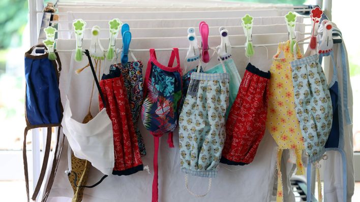 Mehrere selbstgenähte Masken hängen zum Trocknen an einem Wäscheständer (Quelle: imago images/Frank Sorge)