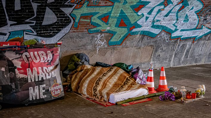 Eine obdachlose Person liegt unter einer Decke auf der Straße. (Quelle: imago-images/Jürgen Ritter)