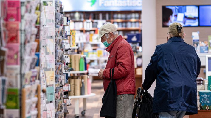 Ein Rentner kauft im Buchladen mit Mundschutz ein (Quelle: dpa/Markus Gilliar)