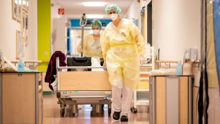 Krankenpflegerinnen schieben am 10.11.2020 einen Patienten am frühen Morgen durch einen Gang auf der Covid-19-Station des Krankenhauses Bethel Berlin. (Quelle: dpa/Kay Nietfeld)