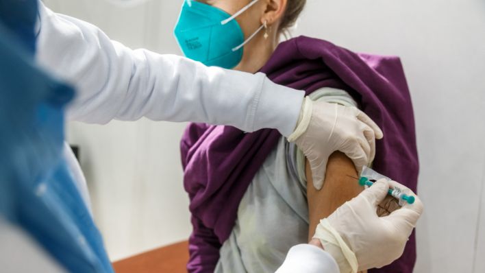 Eine junge Frau erhält eine Impfung (Quelle: dpa/Markus Scholz)