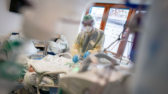 Ein Intensivpfleger arbeitet in Schutzausrüstung auf der Intensivstation des Krankenhauses Berlin Bethel an einem Corona-Patienten