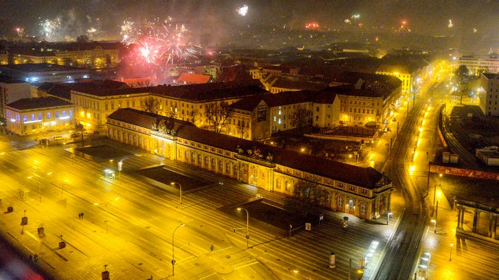 Archivbild: Blick vom Hotel Mercure auf die beleuchtete Breite Straße und das Filmmuseum während in der Silvesternacht Feuerwerk in den Nachthimmel aufsteigt. (Quelle: dpa/Kurt Meyer)