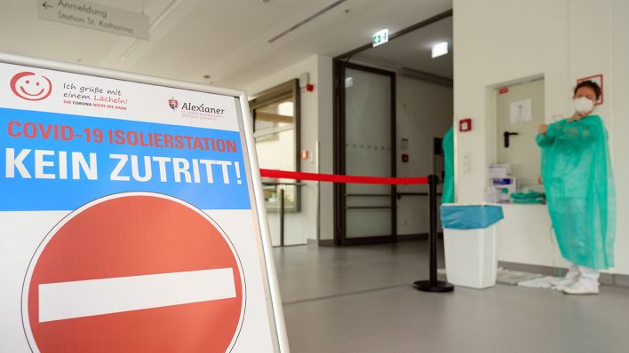 Symbolbild: Eine Ärztin zieht sich im St. Josefs-​​Krankenhaus Potsdam-​​Sanssouci am Eingang zur Station für an Corona erkrankte Patienten einen grünen Kittel an. (Quelle: dpa/S. Stache)