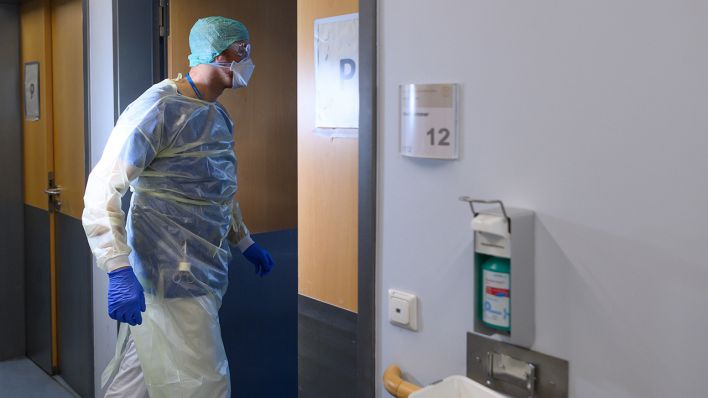 Symbolbild: Ein Pfleger geht in der Corona-Notaufnahme einer Klinik. (Quelle: dpa/R. Michael)