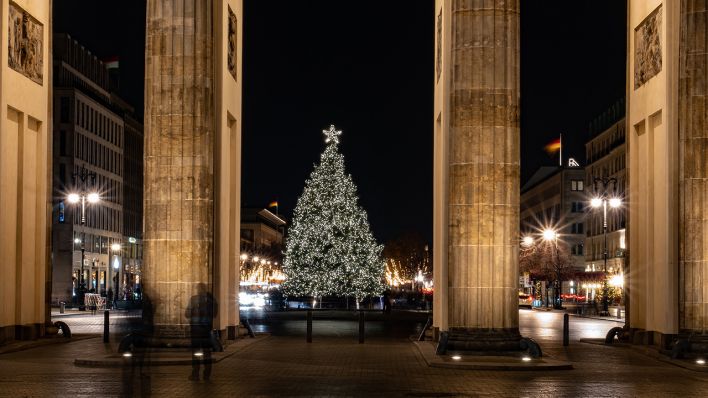 Symbolbild: Durch die Säulen des Brandenburger Tors in Berlin Tiergarten ist der Weihnachtsbaum am Pariser Platz zu sehen. (Quelle: dpa/P. Zinken)