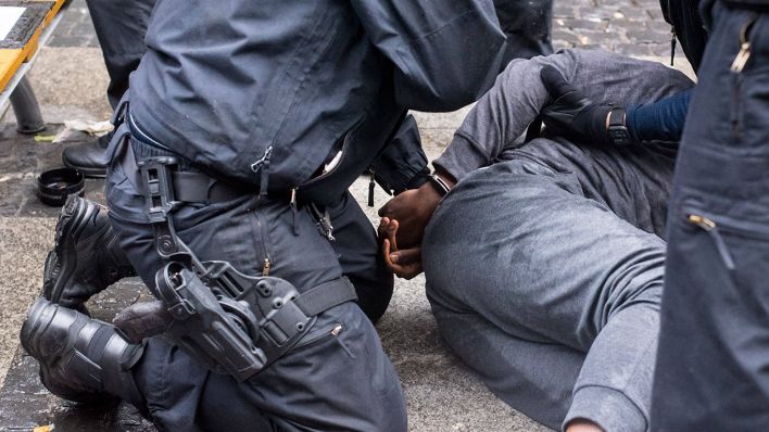 Am Rande einer Demo in Berlin nimmt die Polizei eine schwarze Person fest (Quelle: imago-images/Christian Spicker)