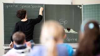 Archivbild: Eine Lehrerin schreibt in einer Grundschule Wörter an eine Tafel