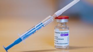 Eine Spritze ist an eine Ampulle mit dem Corona-Impfstoff von AstraZeneca gelehnt. (Quelle: dpa)