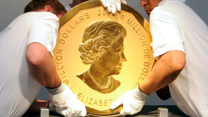 Mitarbeiter eines Auktionshauses heben ein Exemplar der sogenannten «Big Maple Leaf»-Goldmünze an ihren Platz. (Quelle: dpa/Hans Klaus Techt)