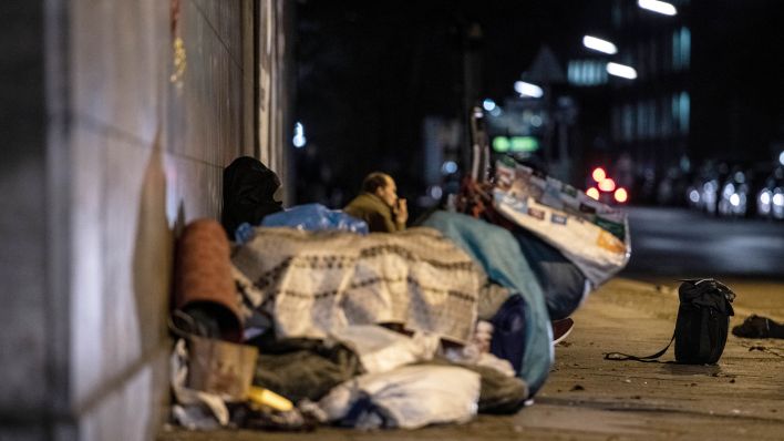 Symbolbild: Obdachlose Menschen liegen und sitzen unter einer Brücke in Berlin (Quelle: dpa/Paul Zinken)