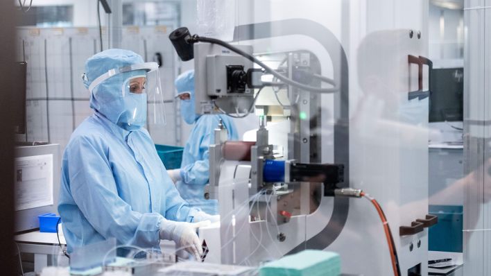 Symbolbild: Mitarbeiter arbeiten in Schutzanzügen in dem Labor eines Biotech-Unternehmens. (Quelle: dpa/F. Strauch)