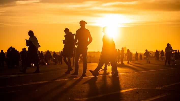 Menschen spazieren während des Sonnenuntergangs bei frühlingshaften Temperaturen auf dem Tempelhofer Feld. (Quelle: dpa/Christophe Gateau)