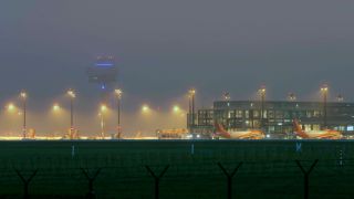 Archivbild: Der Flughafen BER im Nebel. (Quelle: imago images/J. Eckel)