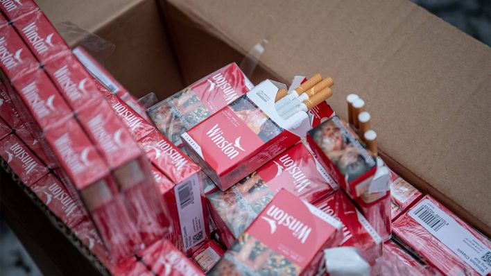Geschmuggelte Zigaretten liegen in einem Pappkarton (Bild: imago images/Sander Ilvest)
