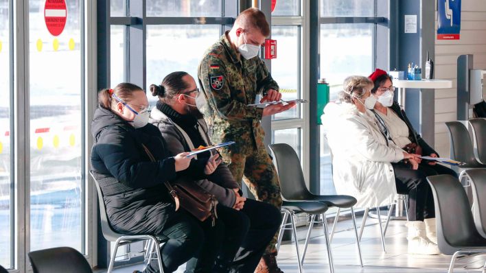 Impfzentrum Schönefeld, 15.02.2021 - Impflinge und ein Soldat der Bundeswehr im Impfzentrums im Terminal 5 des BER Flughafens. (Quelle: imago-images/Jochen Eckel)