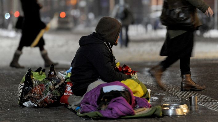 Ein obdachloser Mann sitzt bei minus Grad Celsius auf der Straße (Quelle: dpa/ Ingo Wagner)