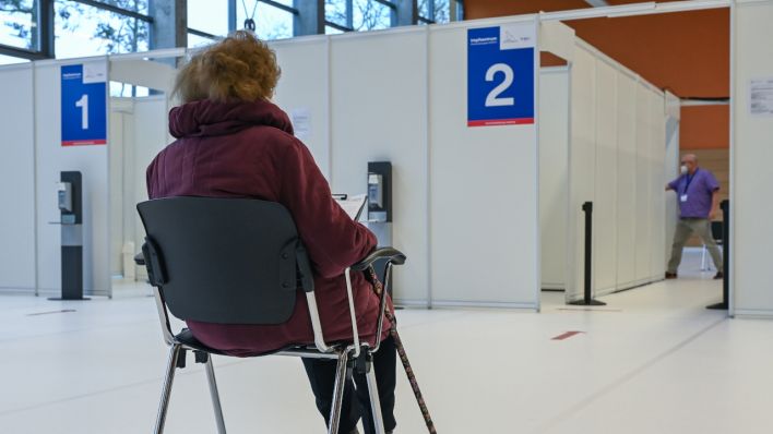 Eine ältere Frau wartet auf ihre Schutzimpfung gegen Covid-19 im Impfzentrum Eberswalde (Quelle: DPA/Patrick Pleul)