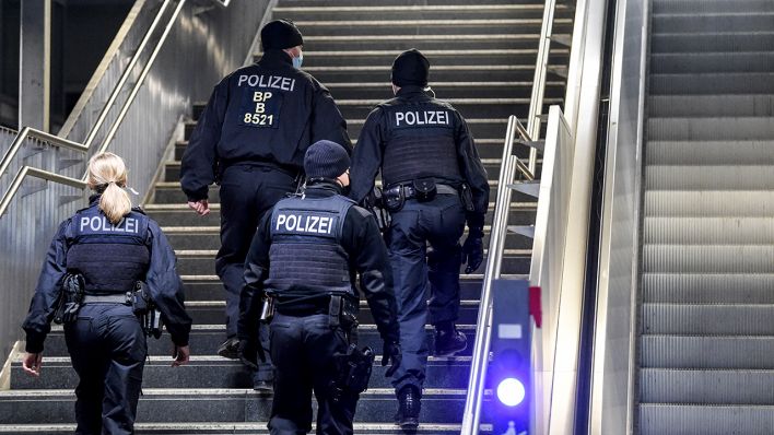 Drei Polizisten und eine Polizistin gehen über den Bahnhof Ostkreuz (Bild: dpa/Kira Hofmann)