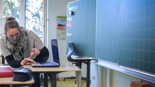 Die Sonderpädagogin Annika Richter überprüft in einem Klassenzimmer der Comenius-Schule vor Beginn der Schulstunde den Laptop (Bild: dpa/Soeren Stache)