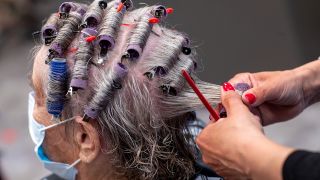 Symbolbild: Einer Kundin werden in einem Friseursalon die Haare frisiert. (Quelle: dpa/Jens Büttner)