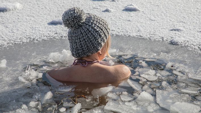 Eine Frau beim Eisbaden bei einer gefrorenen Wasserfläche im Winter. (Quelle: dpa/Fritsch)