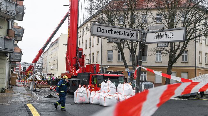 Nach dem Wassereinbruch in einer Baugrube sind Kräne in der Pohlestraße in Berlin-Köpenick im Einsatz, und die Straße ist für den Verkehr gesperrt. (Quelle: dpa/Jens Kalaene)