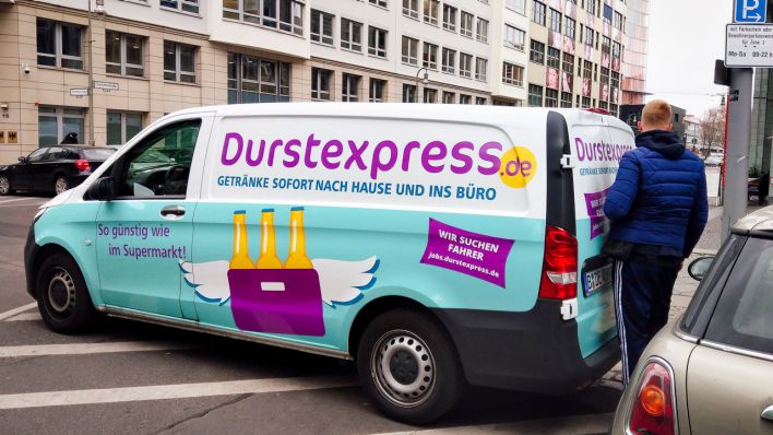 Ein Fahrer von"Durstexpress" steht in Berlin am 12.04.2019 mit einem Lieferwagen an der Zimmerstraße in Mitte, wo er Getränke in ein Büro liefert. (Quelle: dpa/Wolfram Steinberg)