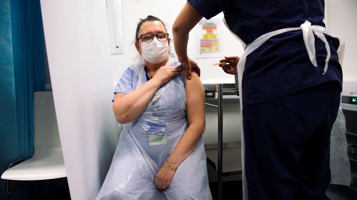 Symbolbild: Eine Pflegerin wird geimpft (Quelle: dpa/Jacob King)