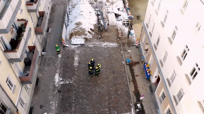 Ein haus in Berlin Köpenick wird von oben gezeigt, auf der Straße stehen Feuerwehrkräfte. Das Haus steht neben einer Baugrube und musste evakuiert werden, um die Stabilität zu prüfen. (Quelle: rbb)