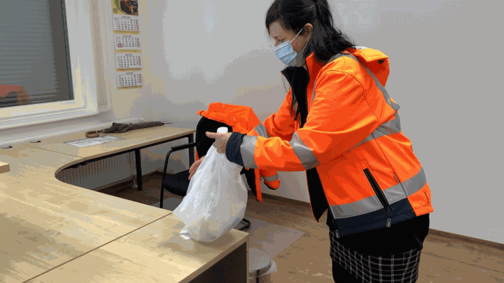 Eine Müllwerkerin zeigt, wie man "Corona-Müll" fachgerecht entsorgt. (Bild: rbb)