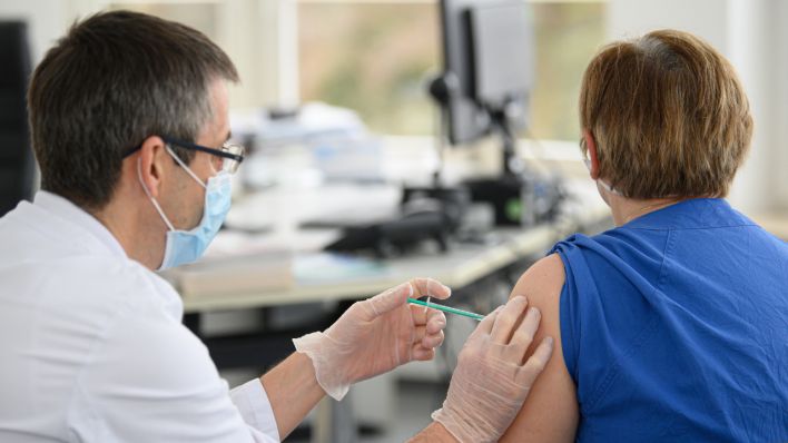 Ein Arzt impft eine Frau mit dem Impfstoff von Biontech/Pfizer gegen das neuartige Coronavirus. (Quelle: dpa/Robert Michael)