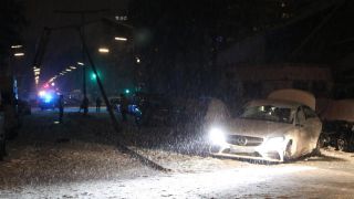 Ein verunfallter Mercedes steht auf einer zugeschneiten Straße in Berlin-Wedding, davor liegt ein umgeknickter Laternenmast (Quelle: Pudwell)