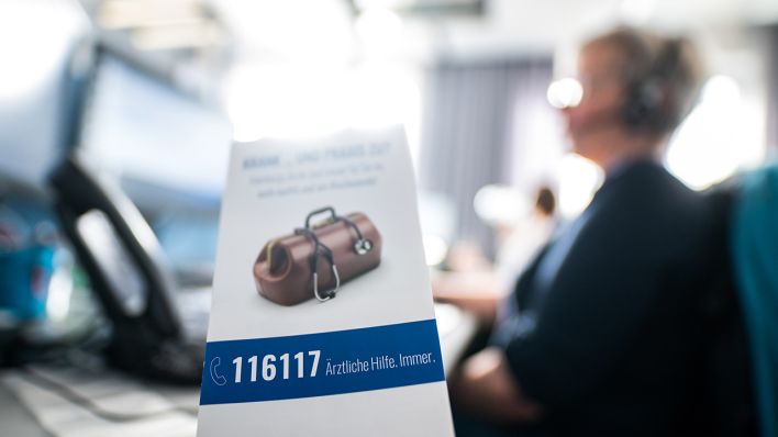 Symbolbild: Ein Flyer für die Rufnummer des ärztlichen Bereitschaftsdienstes «116117», aufgenommen in einer Telefonzentrale für den Bereitschaftsdienst der Kassenärztlichen Vereinigung Hamburg (Bild: dpa/Daniel Reinhardt)