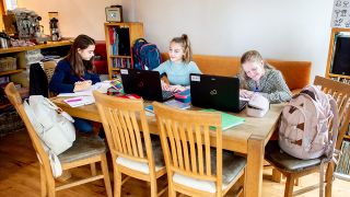 Symbolbild - Drei Kinder sitzen zusammen im Wohnzimmer und lernen. (Bild: dpa/Hauke-Christian Dittrich)