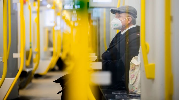 Ein Mann sitzt mit FFP2-Maske in der U-Bahn. (Quelle: dpa/Christoph Soeder)