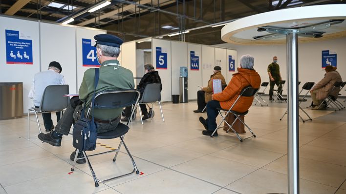 Mehrere ältere Menschen sitzten im Wartebereich des Impfzentrums im Terminal 5 am ehemaligen Flughafen Schönefeld