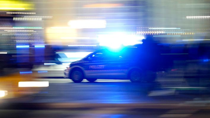 Ein Polizeiwagen fährt durch das nächtliche Berlin mit eingeschaltetem Blaulicht (Quelle: Geisler-Fotopress/Thomas Bartilla)