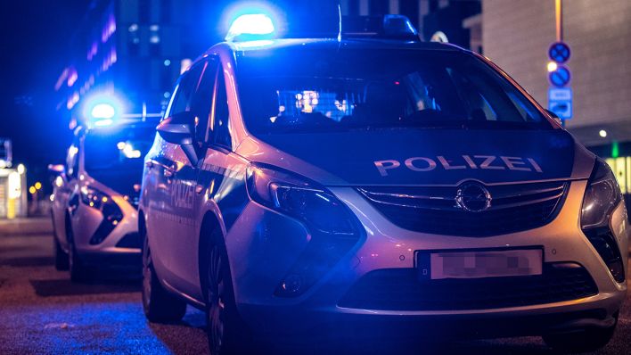 Symbolbild: Zwei Polizeiwagen stehen mit Blaulicht vor einem Gebäude in Berlin. (Quelle: dpa/A. Gora)