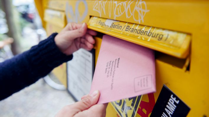 ILLUSTRATION - Eine Frau wirft in Berlin ihre Briefwahlunterlagen für die Bundestagswahl in den Briefkasten. (Quelle: dpa/Maurizio Gambarini)