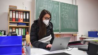 Schulunterricht in Zeiten der Coronavirus Pandemie. Eine Lehrerin sitzt an ihrem Schreibtisch und arbeitet an ihrem Laptop. (Quelle: dpa/Frank Hoermann)