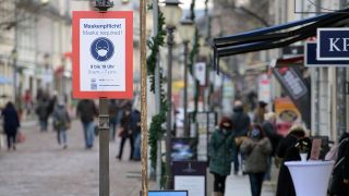 Archivbild: Ein Schild weist die Passanten in der Brandenburger Straße auf die Pflicht zum Tragen einer Maske hin. (Quelle: dpa/S. Stache)