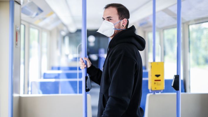 ILLUSTRATION - Ein junger Mann trägt in einer Stadtbahn eine Atemschutzmaske der Kategorie FFP2 (Quelle: dpa/Christoph Schmidt)