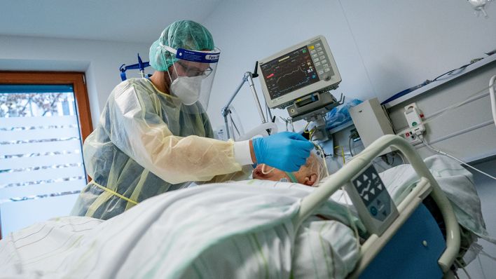 Symbolbild: Ein Intensivpfleger arbeitet in Schutzausrüstung auf der Intensivstation eines Krankenhauses. (Quelle: dpa/K. Nietfeld)