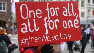 Archivbild: Ein Demonstrant hält vor dem Rathaus ein Plakat mit der Aufschrift "One for all, all for one #freenavalny". Auf dem Marktplatz haben rund 200 Menschen für die Freilassung des politischen Gefangenen A. Nawalny demonstriert. Quelle: dpa/David Young