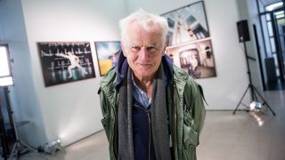 Der Fotograf Jim Rakete steht in der Kunsthalle vor seinen Bildern von Olympiasiegern an Hamburger Kulturorten. Quelle: Christian Charisius/dpa