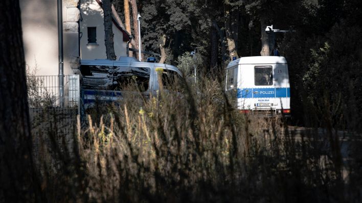 Fahrzeuge der Polizei stehen im Rahmen einer Durchsuchung auf einem Grundstück in Brandenburg. (Quelle: dpa/Zinken)